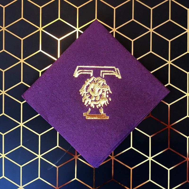 Metallic gold logo printed on a plum airlaid napkin